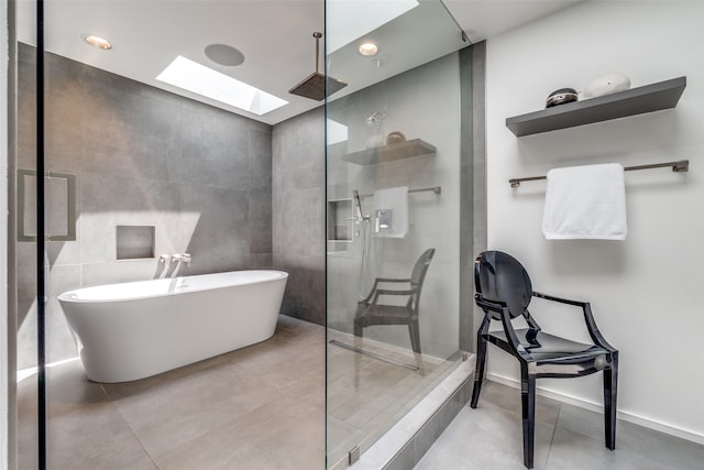 bathroom with a shower with shower door, tile walls, tile patterned floors, and a skylight