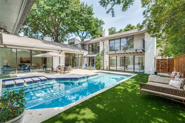 view of swimming pool featuring a patio area and a yard