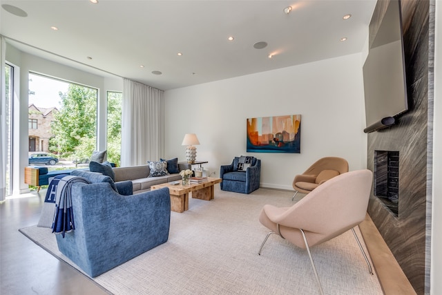 living room with a premium fireplace and concrete flooring