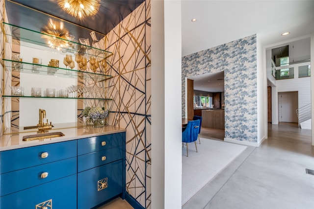 bar with sink and blue cabinetry