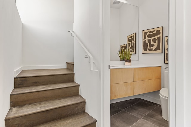 stairs featuring dark tile patterned flooring