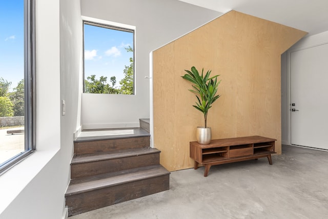 stairway with concrete flooring and a wealth of natural light