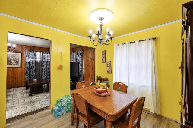 dining space featuring hardwood / wood-style floors, ornamental molding, and a chandelier