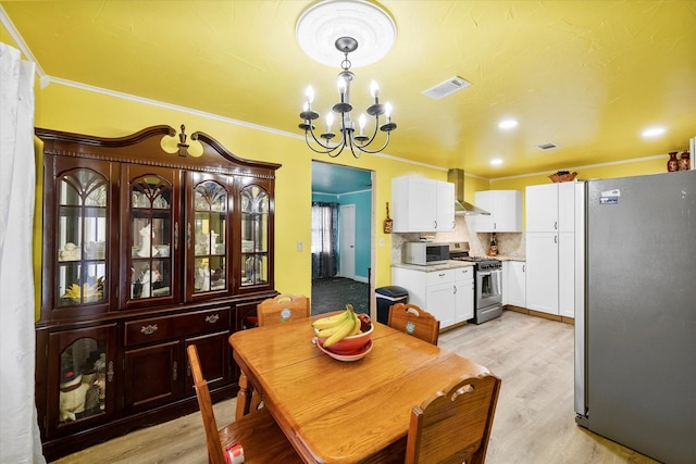 dining room featuring a notable chandelier, ornamental molding, and light hardwood / wood-style floors