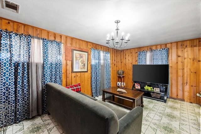 living room featuring a chandelier and wood walls