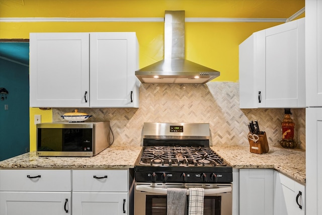 kitchen with tasteful backsplash, island range hood, white cabinets, and appliances with stainless steel finishes