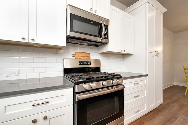 kitchen featuring backsplash, white cabinetry, dark hardwood / wood-style floors, and stainless steel appliances