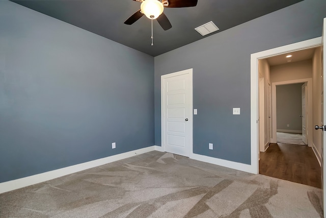 unfurnished bedroom featuring dark carpet, ceiling fan, and a closet