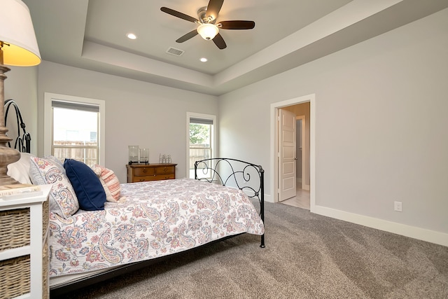 bedroom with a tray ceiling, carpet floors, and ceiling fan