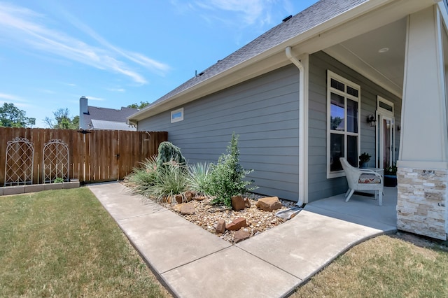 view of side of property featuring a yard and covered porch