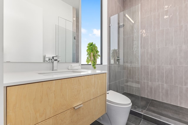 bathroom featuring tile patterned flooring, a shower with door, toilet, and vanity