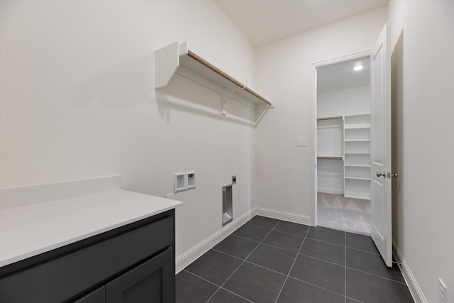 laundry room with washer hookup, hookup for an electric dryer, dark tile patterned flooring, and cabinets