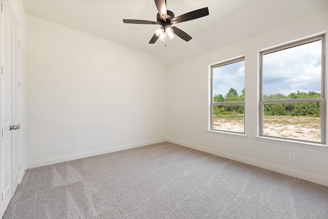 spare room with light colored carpet, ceiling fan, and vaulted ceiling