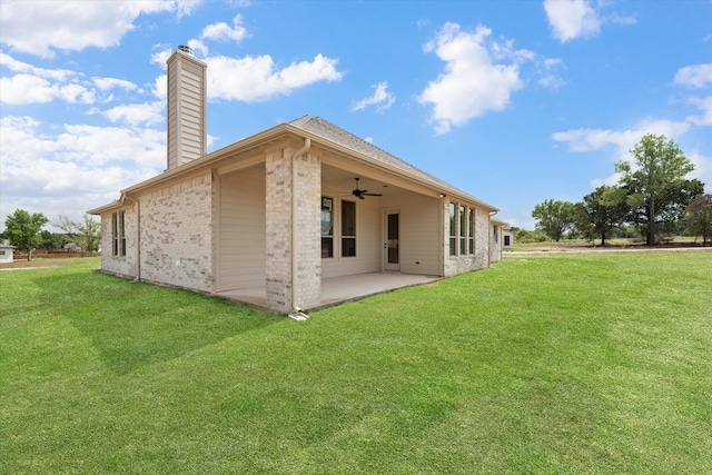 back of property with ceiling fan, a lawn, and a patio area