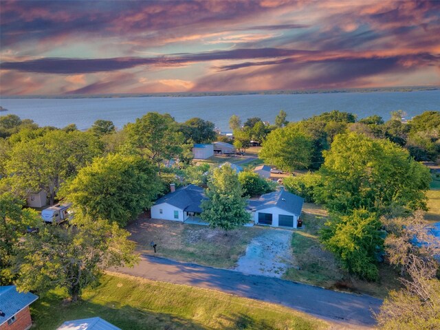 aerial view at dusk featuring a water view