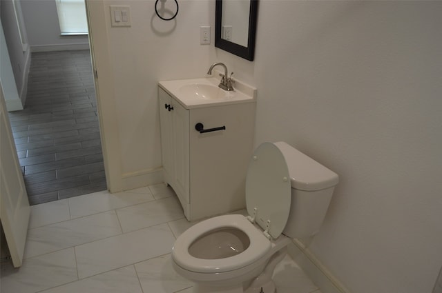 bathroom featuring vanity, tile patterned flooring, and toilet