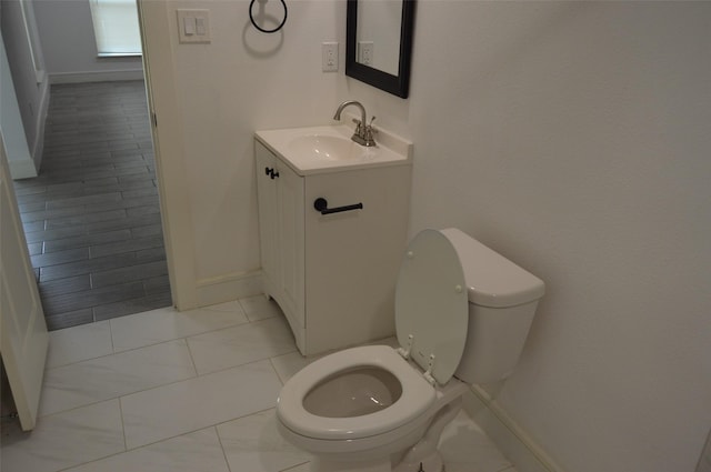 bathroom featuring vanity, toilet, and tile patterned flooring