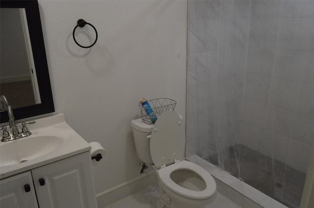 bathroom with vanity, tile patterned floors, a tile shower, and toilet