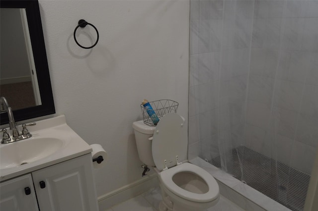 bathroom featuring tile patterned floors, toilet, vanity, and a tile shower