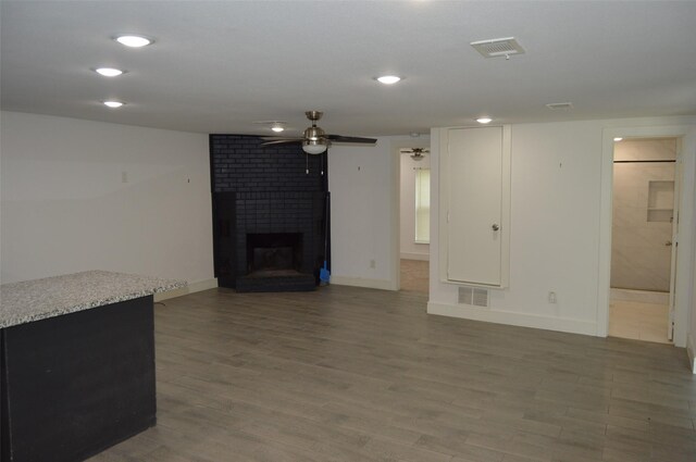 unfurnished living room with a fireplace, ceiling fan, and hardwood / wood-style floors