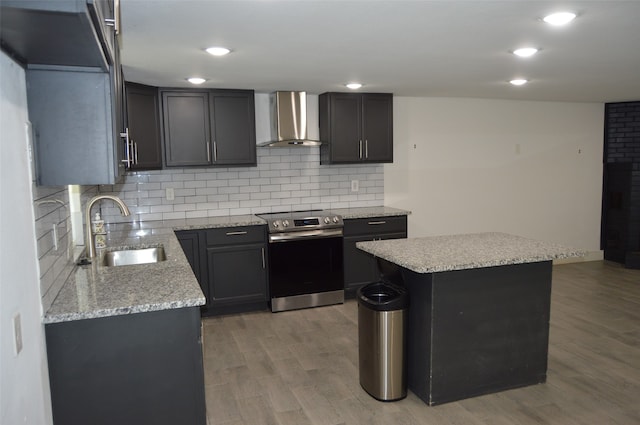 kitchen with light hardwood / wood-style floors, sink, wall chimney exhaust hood, and stainless steel electric stove