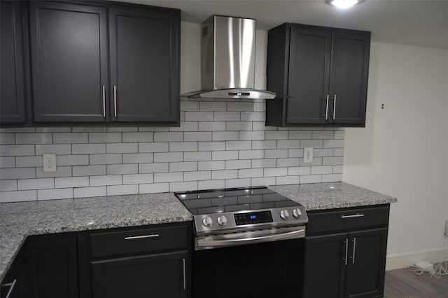 kitchen with wall chimney range hood, electric stove, tasteful backsplash, and wood-type flooring