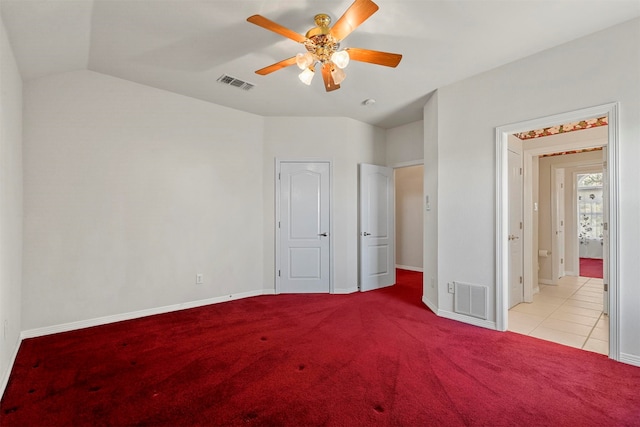 unfurnished bedroom featuring ceiling fan, light colored carpet, and vaulted ceiling