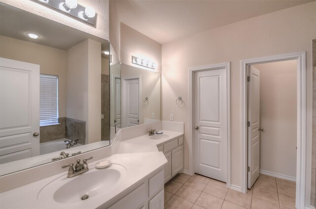 bathroom featuring tile patterned floors, dual bowl vanity, and a bathtub