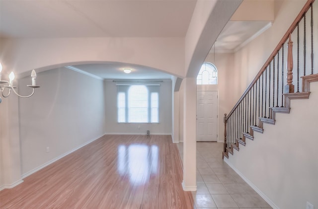 9816 Mullins Crossing Dr, Fort Worth, TX 76126 - entrance foyer with a chandelier, ornamental molding, stairway, light wood-style flooring, and arched walkways