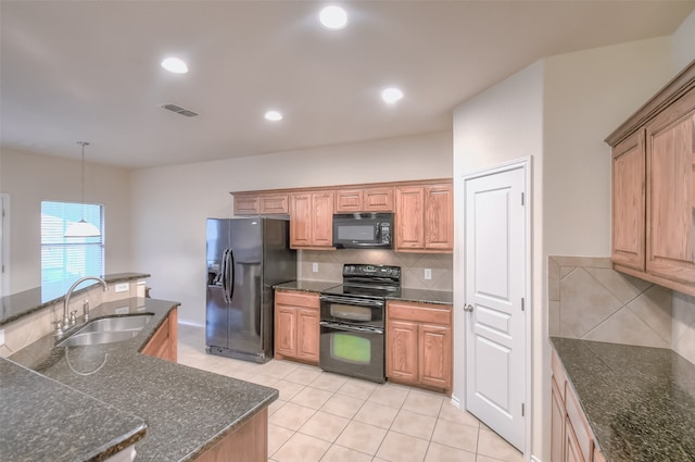 kitchen with light tile patterned flooring, black appliances, decorative light fixtures, tasteful backsplash, and sink