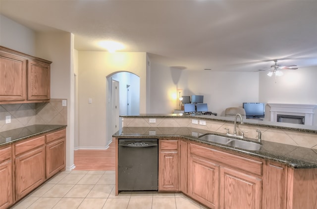 kitchen featuring black dishwasher, tasteful backsplash, sink, light hardwood / wood-style floors, and ceiling fan