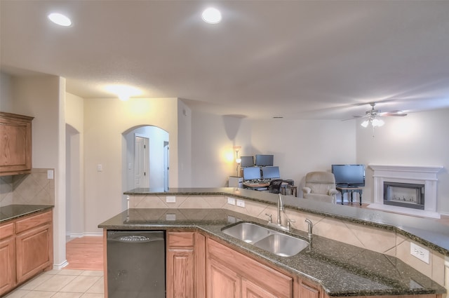 kitchen featuring ceiling fan, tasteful backsplash, sink, dishwasher, and light hardwood / wood-style floors