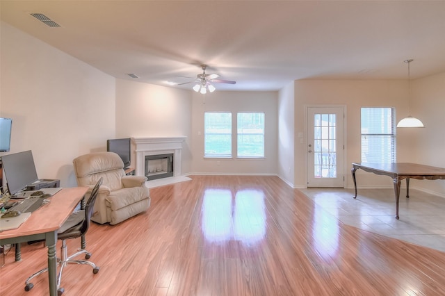 9816 Mullins Crossing Dr, Fort Worth, TX 76126 - living area with a ceiling fan, a fireplace with raised hearth, light wood finished floors, baseboards, and a desk