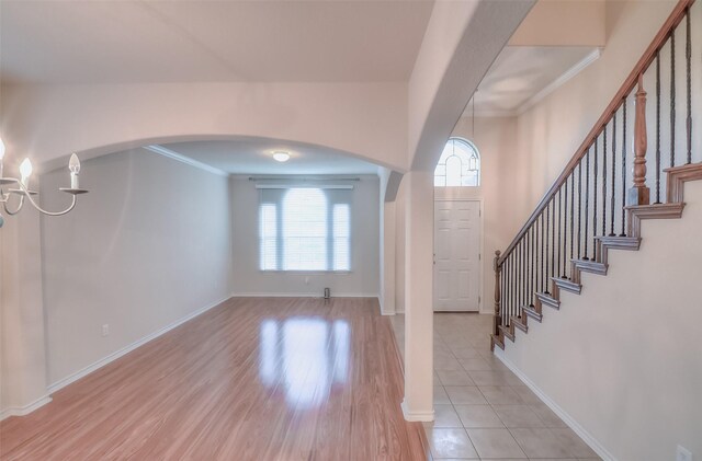 entryway with crown molding and light wood-type flooring