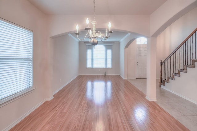 9816 Mullins Crossing Dr, Fort Worth, TX 76126 - foyer with a chandelier, arched walkways, light wood-style flooring, baseboards, and stairway