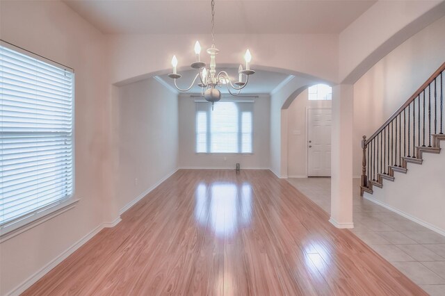 unfurnished dining area with light hardwood / wood-style flooring and a chandelier