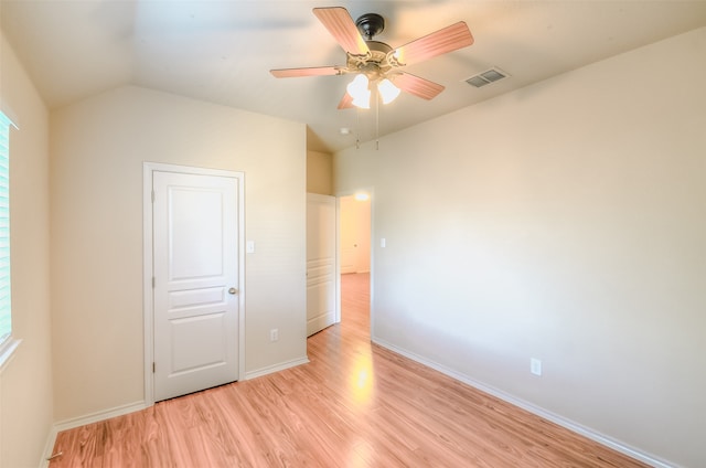 unfurnished bedroom featuring vaulted ceiling, light wood-type flooring, and ceiling fan