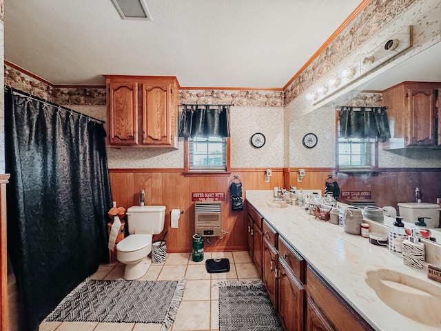 bathroom with heating unit, vanity, a wealth of natural light, and wood walls