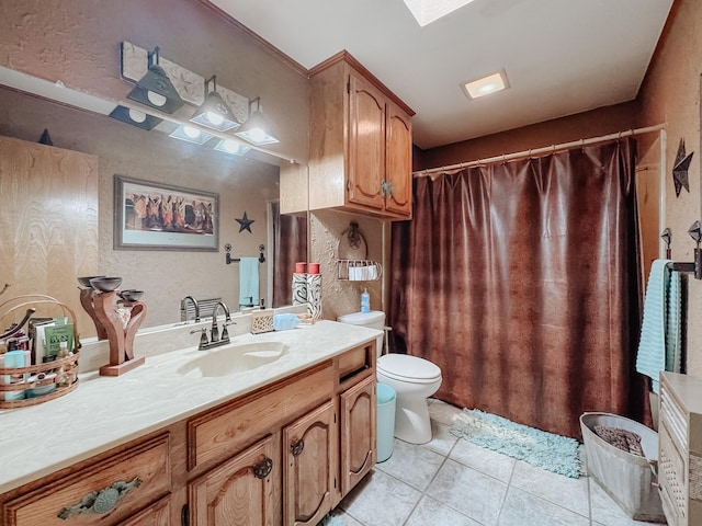 bathroom featuring tile patterned floors, toilet, vanity, and a skylight