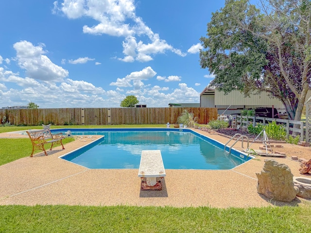 view of swimming pool with a diving board and a patio