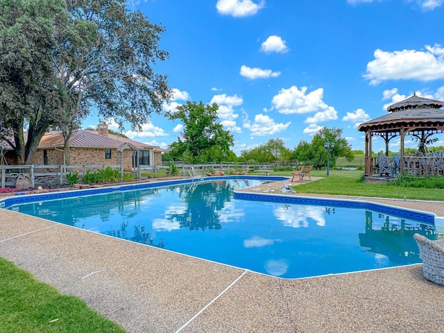 view of swimming pool with a gazebo and a yard