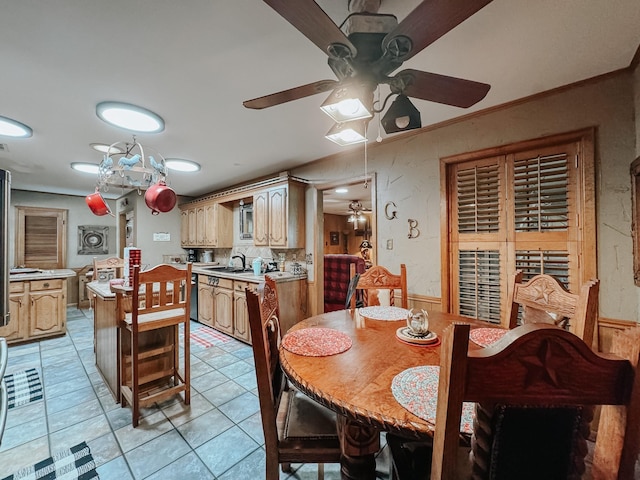 dining space featuring sink, ornamental molding, and light tile patterned flooring