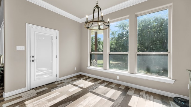 unfurnished dining area with an inviting chandelier, a wealth of natural light, crown molding, and wood-type flooring