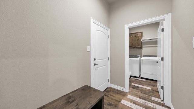 hall featuring washing machine and clothes dryer and dark wood-type flooring