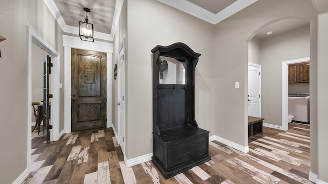 foyer entrance featuring washer / dryer, dark wood-type flooring, and ornamental molding