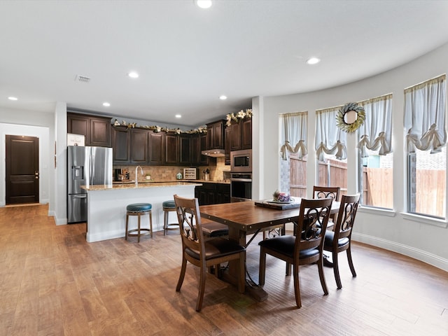 dining area with light hardwood / wood-style floors and sink