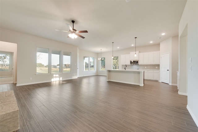 unfurnished living room with sink, dark hardwood / wood-style floors, and ceiling fan