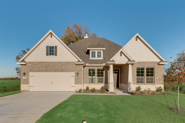 view of front of property with a front yard and a garage