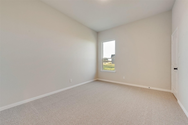 carpeted spare room with lofted ceiling