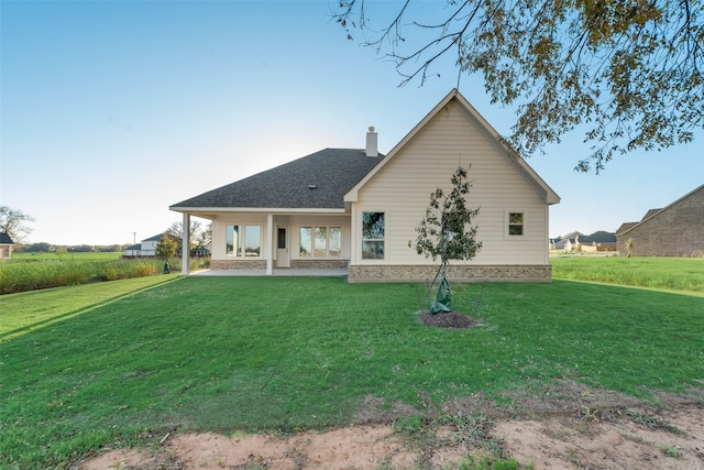 back of property with a patio area and a lawn